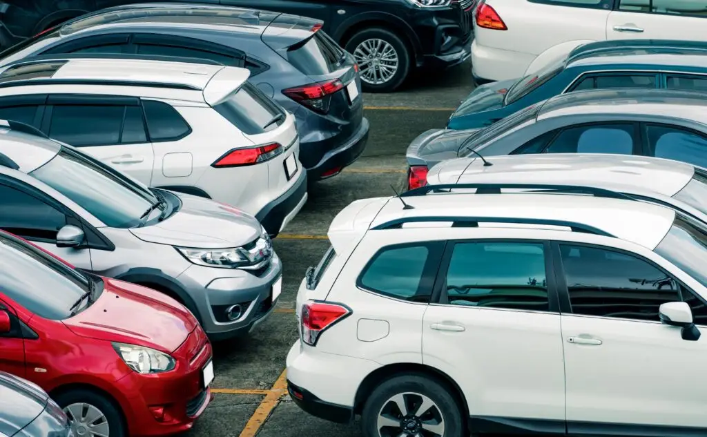 A PMC parking lot with various cars parked closely together, viewed from above.