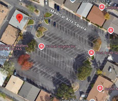 Satellite view of a mostly empty parking lot labeled Medical Arts Square, surrounded by buildings and trees, with several business and medical office names marked on the map.