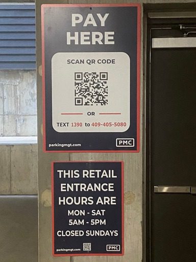 Two signs on a wall: the top sign says "Pay Here" with a QR code and a phone number for payment; the bottom sign lists retail entrance hours, open Monday–Saturday 5am–5pm, closed Sundays.